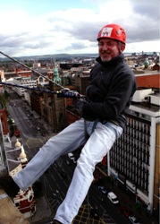 The Rev Patrick McGlinchey, Church of Ireland Chaplain at Queen's University, about to abseil off the roof of the Europa Hotel!